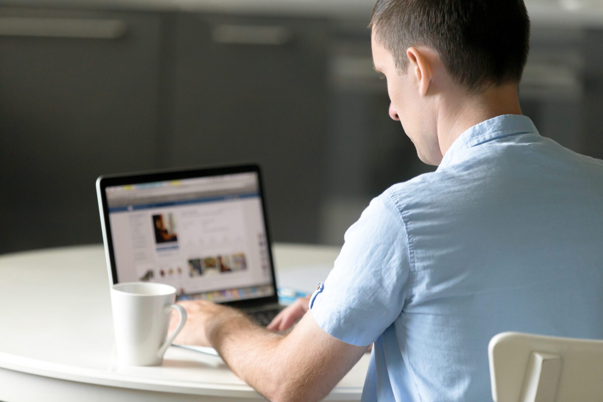 Portrait of a young man working at desk with laptop Website designing
